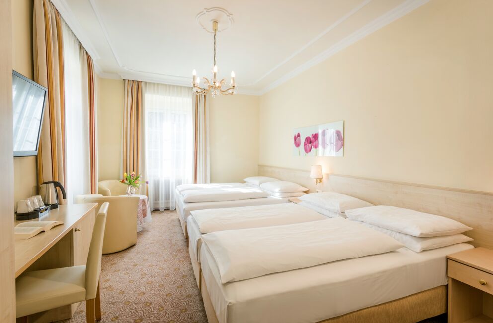 Helles, gemütliches Doppelzimmer mit eleganten Möbeln und sanfter Beleuchtung.