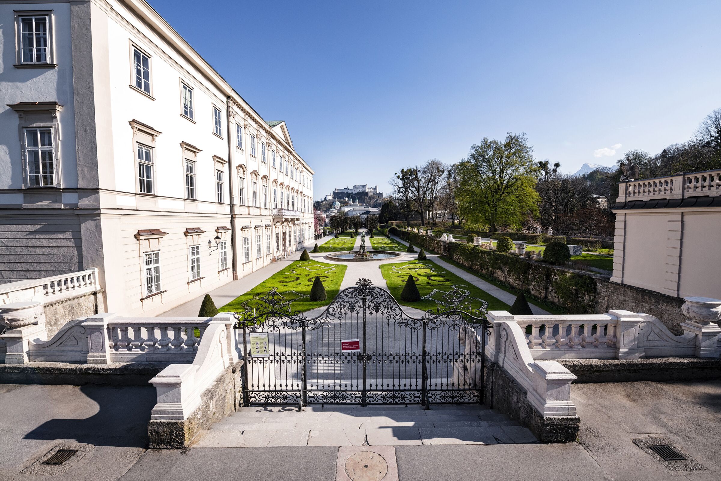 Historisches Gebäude mit gepflegtem Garten und Blick auf die Salzburger Festung.