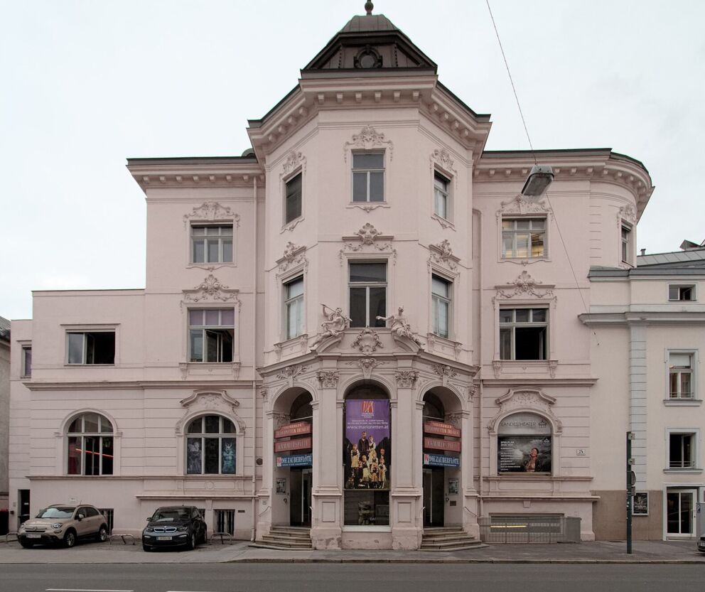 Imposantes historisches Gebäude mit kunstvollen Verzierungen und großen Fenstern an der Straße.