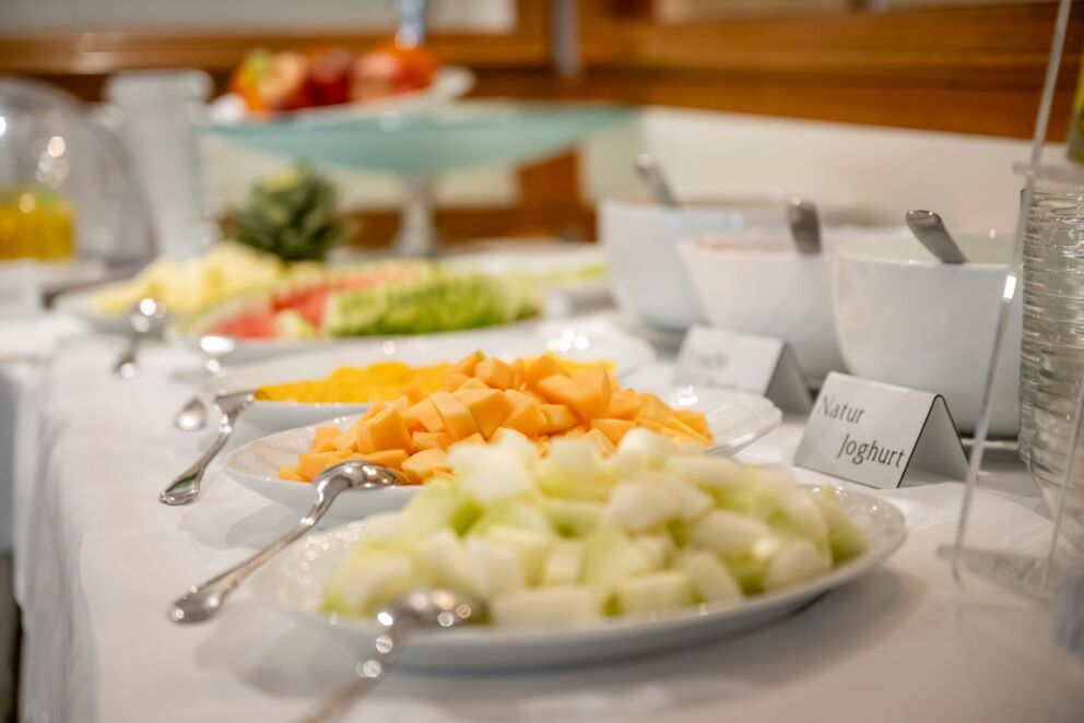 Various fresh fruits and yogurt on a breakfast buffet.