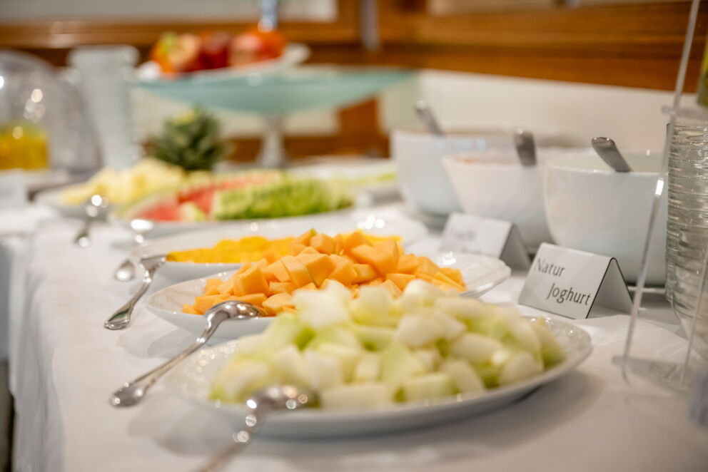 Various fresh fruits and yogurt on a breakfast buffet.