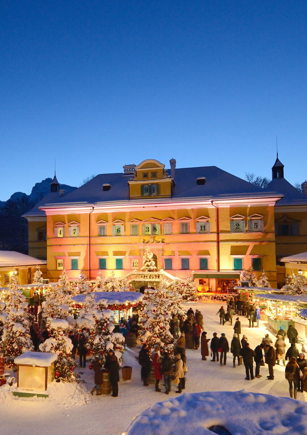 Historischer Weihnachtsmarkt mit Lichtern und Besuchern bei Abenddämmerung im Winterzauber.
