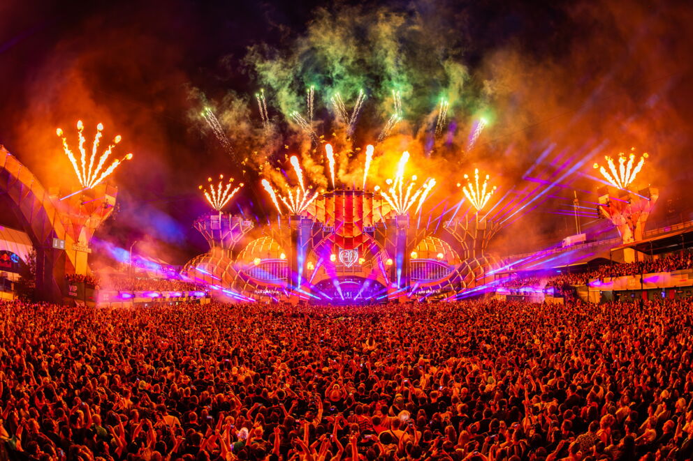 Large audience at a spectacular stage show with colorful fireworks.