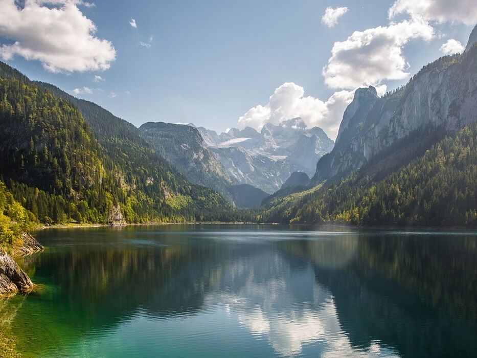Clear mountain lakes, surrounded by majestic mountains and lush nature in the sunlight.