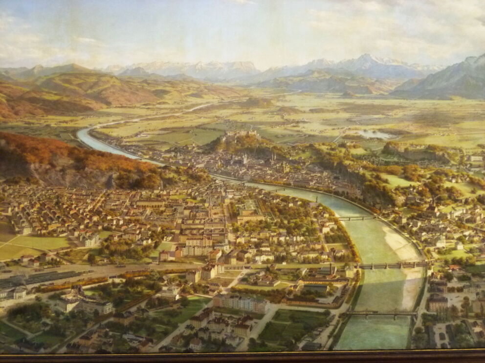 Malerische Ansicht von Salzburg mit Fluss und umliegenden Bergen im Hintergrund.