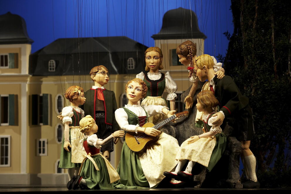 Marionettes in traditional dress in front of a historic building in Salzburg.
