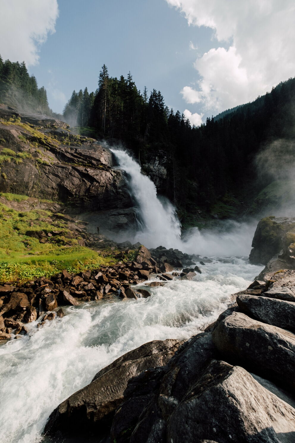 Powerful waterfall plunges into the depths between lush forests and rocks.