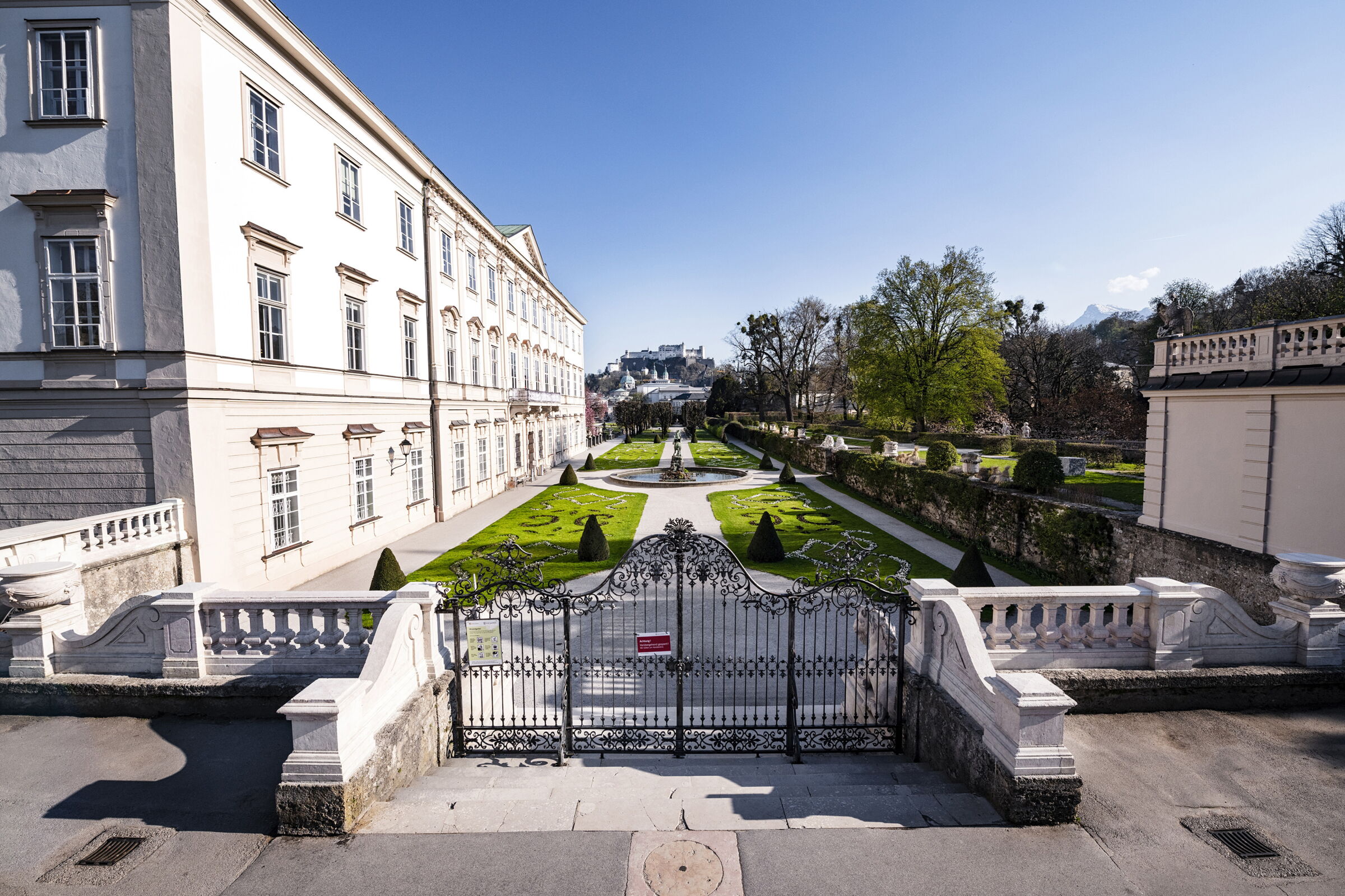 Historic building with well-kept garden and view of the Salzburg fortress.