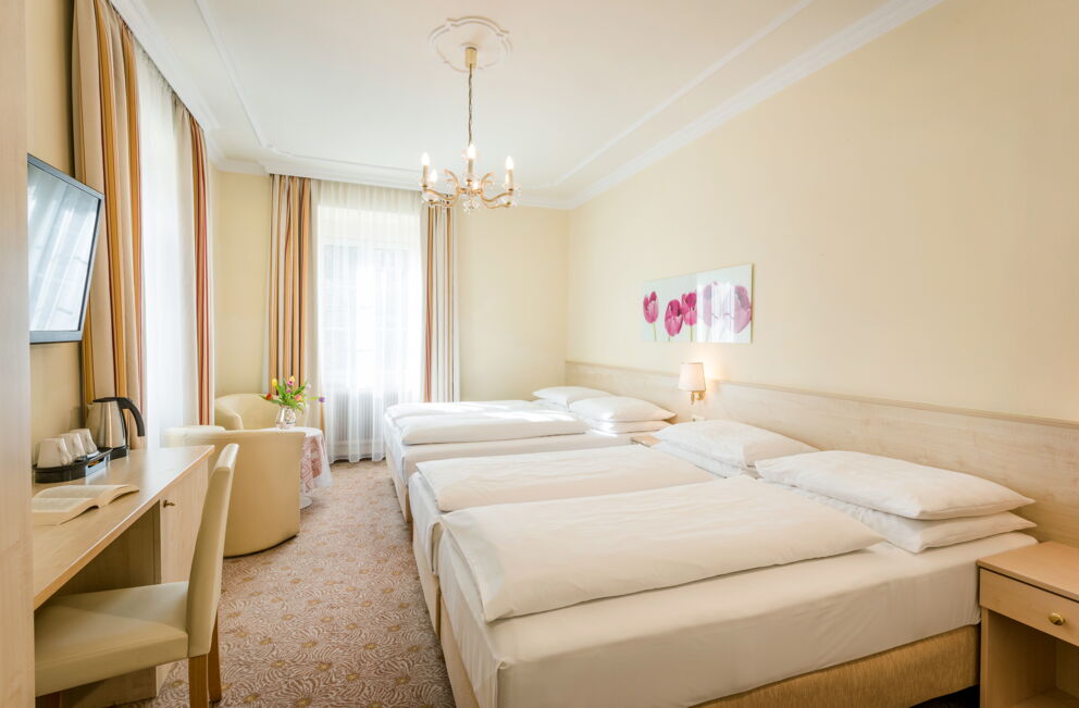 Helles, gemütliches Doppelzimmer mit eleganten Möbeln und sanfter Beleuchtung.