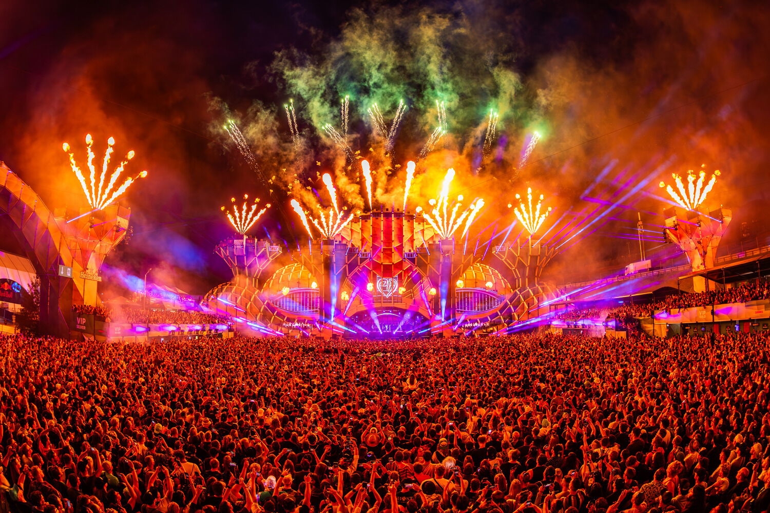Large audience at a spectacular stage show with colorful fireworks.