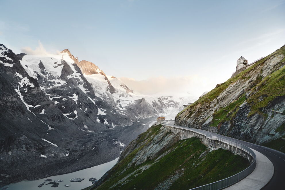 Serpentine road winds its way through an impressive mountain landscape in the sunlight