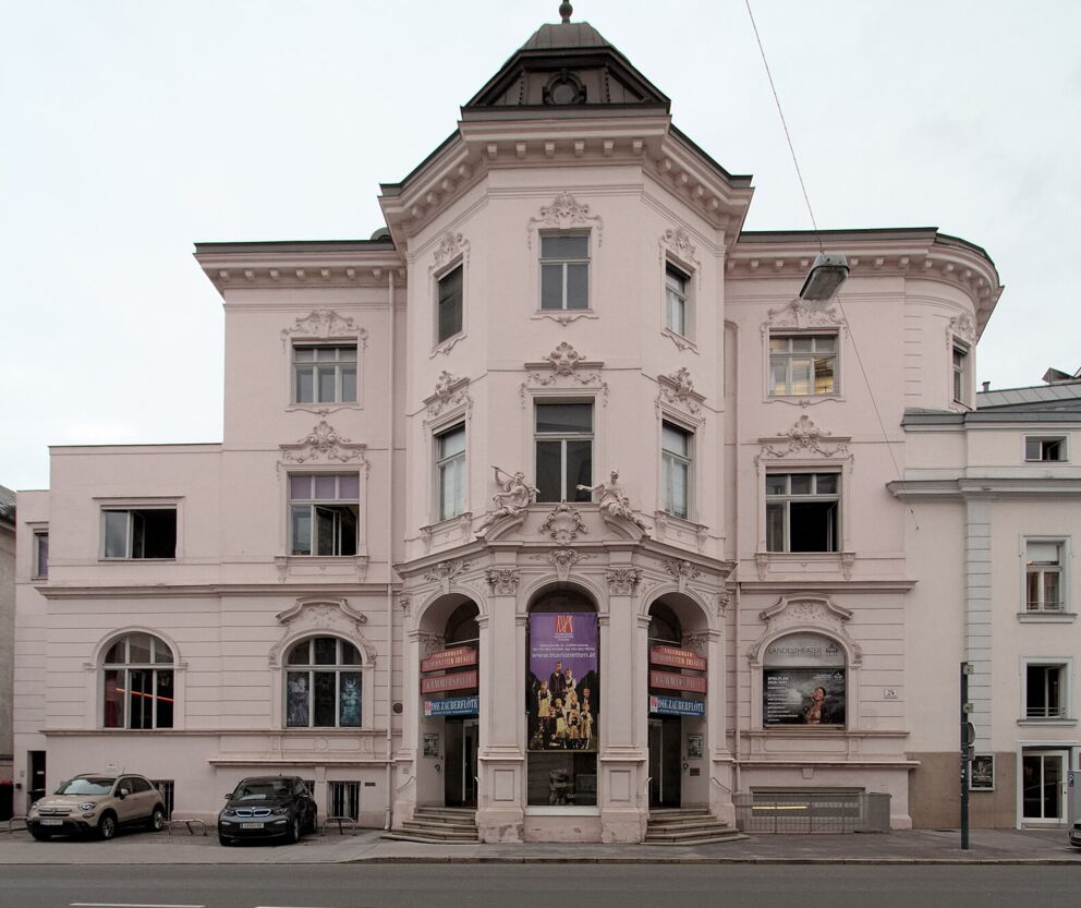 Imposantes historisches Gebäude mit kunstvollen Verzierungen und großen Fenstern an der Straße.