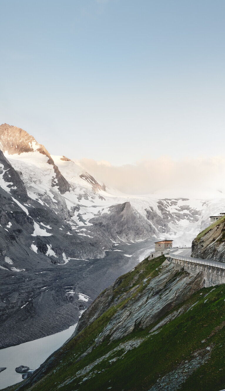 Serpentine führt durch eine beeindruckende, schneebedeckte Berglandschaft unter klarem Himmel.