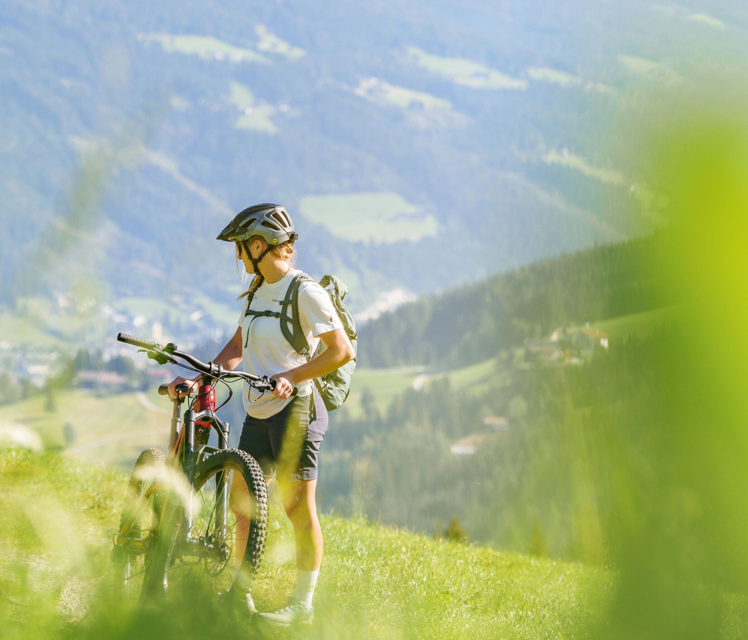Einen Person die ihr Fahrrad hält und auf einer Wiese steht ©Salzburgerland Tourismus Foto: Gerald Oberreiter