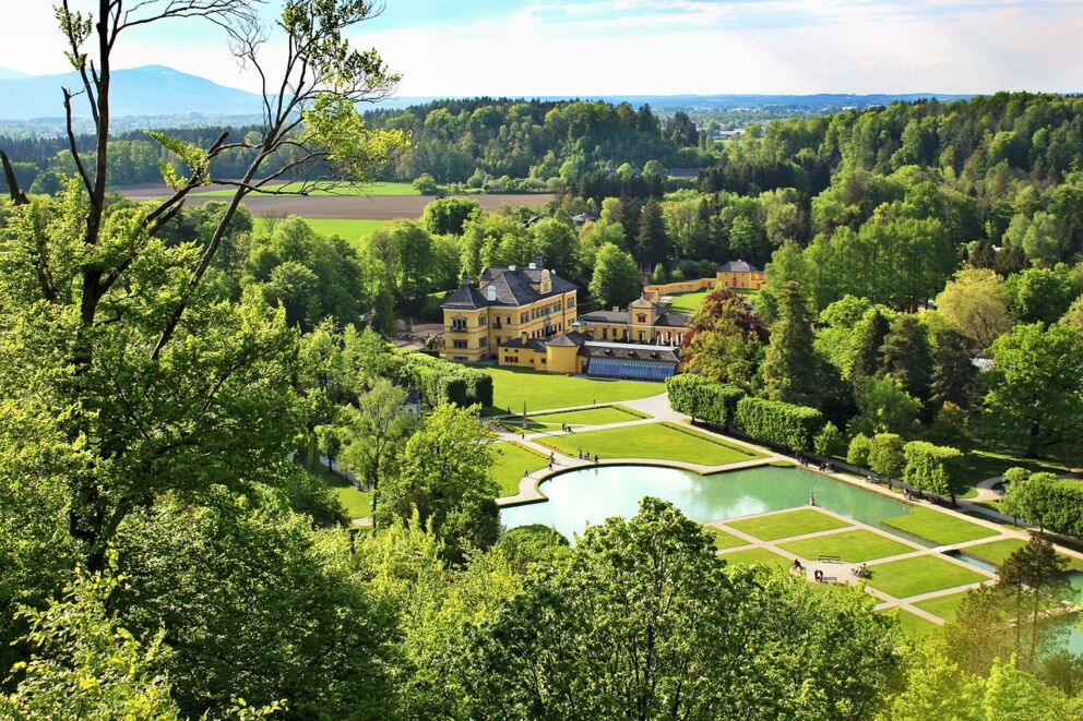 Historic castle with extensive, green park surrounded by lush nature.