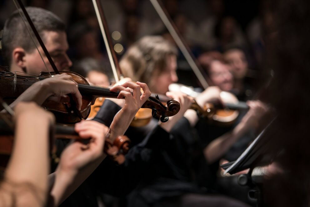 Close-up of musicians playing the violin in an orchestra.